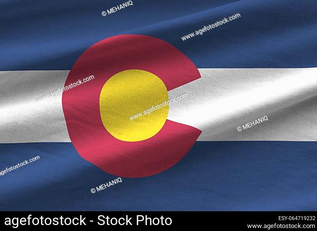 Colorado US state flag with big folds waving close up under the studio light indoors. The official symbols and colors in fabric banner
