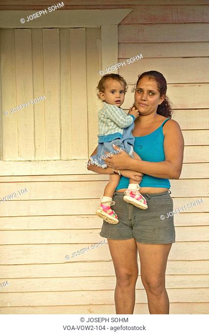 Mother and baby posing on front porch in the Valle de Viñales, in central Cuba