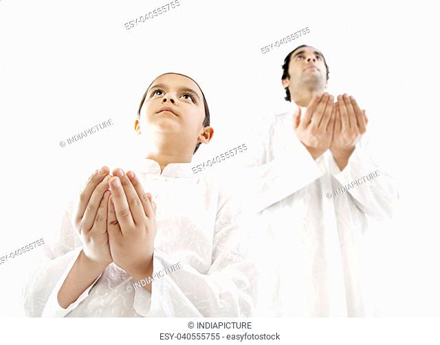 Muslim man and his son praying