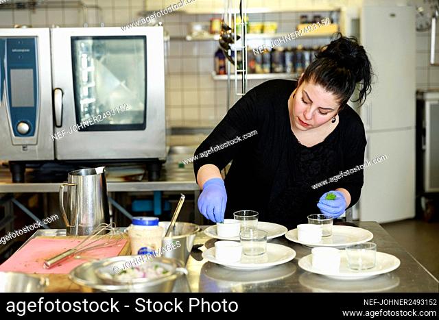 Woman preparing food in restaurant kitchen