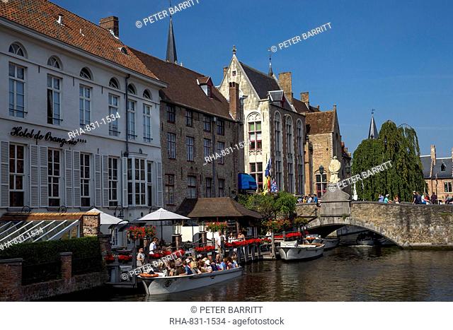 Tourists in boats travel on the Den Dijver canal in summer, Bruges, West Flanders, Belgium, Europe