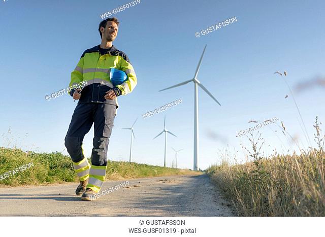 Engineer walking on field path at a wind farm