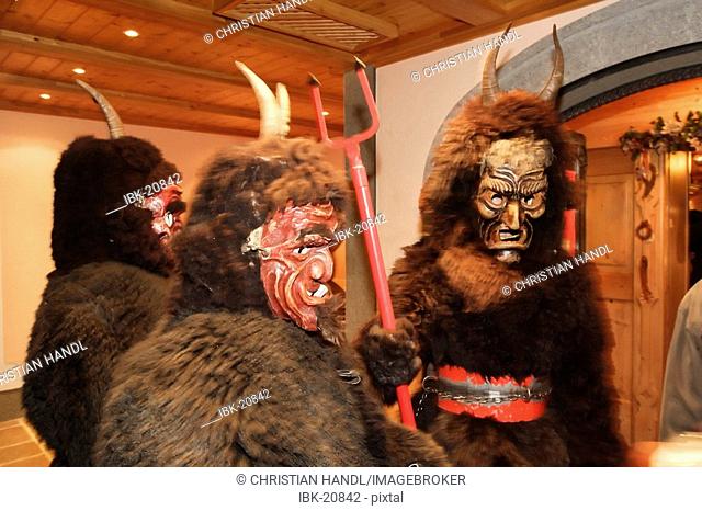 Luzifer is hold by two Krampus which is part of the traditional Mitterndorfer Nikolausplay which is celebrated in the small village of Krungl Styria Austria