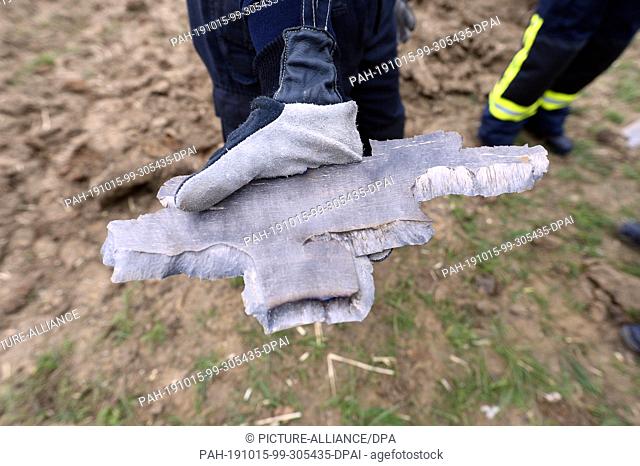15 October 2019, North Rhine-Westphalia, Cologne: An employee of the explosive ordnance disposal service shows a part of a bomb after the detonation of an...