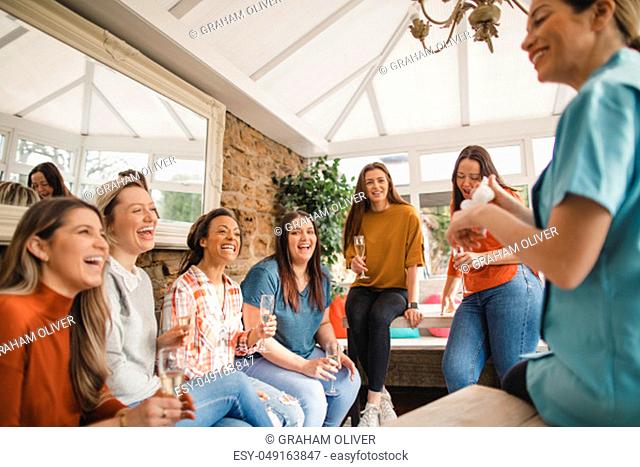 Mid adult beauty sales representative making a sales pitch to a group of women at a product party