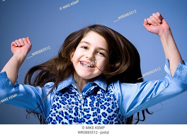 Portrait of a girl smiling with her arms raised