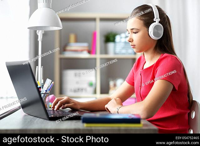 girl in headphones with laptop computer at home
