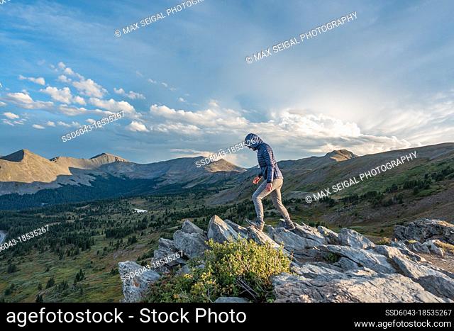 Woman hiking alonf rock formation ridge in Colorado Alpine