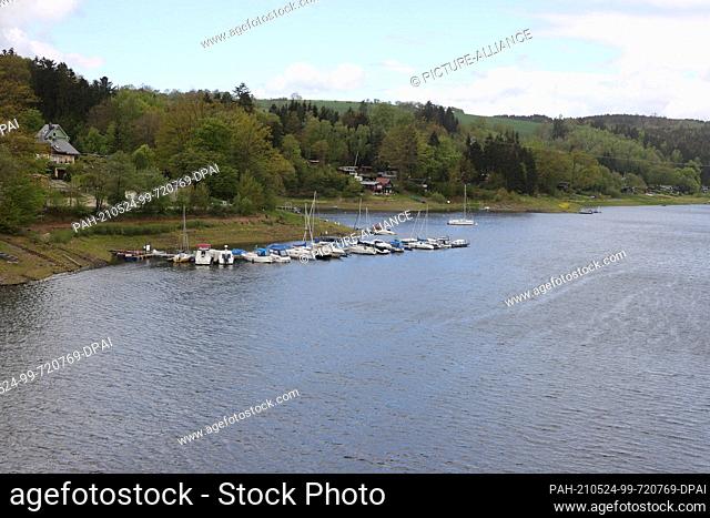 23 May 2021, Thuringia, Saalburg: Boats are moored on the banks of the Bleilochtalsperre. Visitors take advantage of the beautiful weather on Whitsunday for a...
