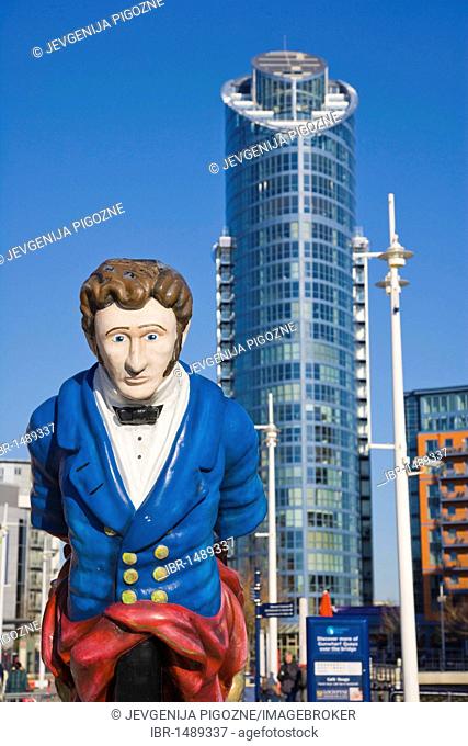 Figurehead from the former HMS Vernon ship at canalside of Gunwharf Quays with The Number One Tower, Lipstick, at back, Portsmouth, Hampshire, England