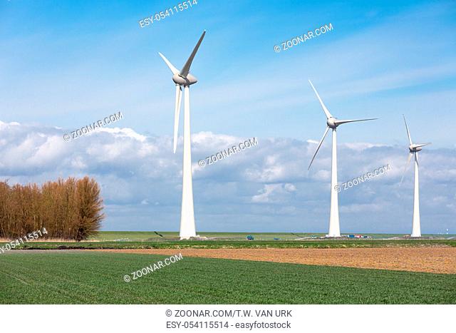 Farmland with wind turbines of the biggest windfarm in the Netherlands. The axle height of these turbines is 135 meter and the wings have a peak height of...