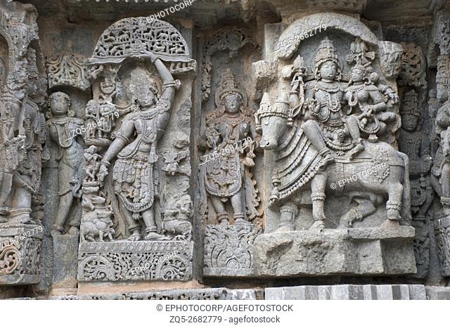 Ornate wall panel reliefs depicting (From left) Krishna as Govardhan Giridhari and Shiva-Parvati seated on Nandi, Kedareshwara temple, Halebidu, Karnataka