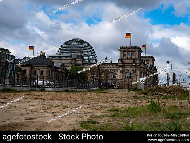 03 May 2021, Berlin: The Reichstag building can be seen behind a wasteland on Schiffbauerdamm. Photo: Paul Zinken/dpa-Zentralbild/dpa