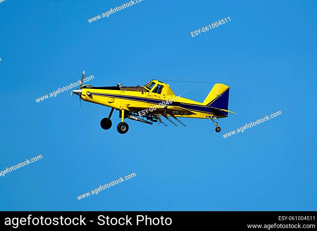 A small crop duster is flying in the sky near Spangle, Washington