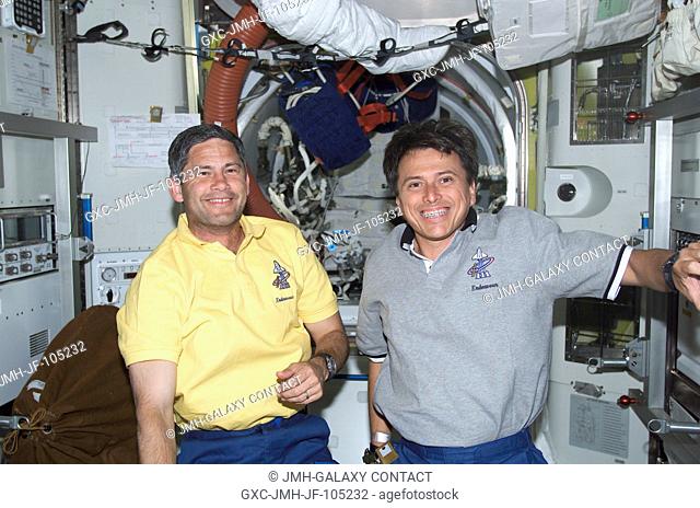 Astronauts Paul S. Lockhart (left), STS-111 pilot, and Franklin R. Chang-Diaz, mission specialist, greet Expedition Four members (out of frame) with smiles...