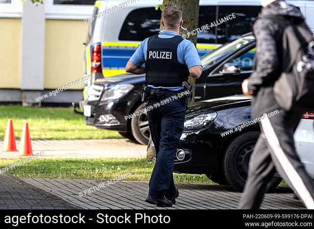 09 June 2022, Hessen, Bad Arolsen: A police officer stands in a parking lot of the Kaulbach secondary school in Bad Arolsen, northern Hesse