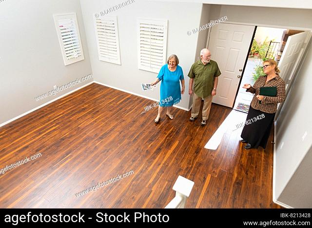 Female real estate agent showing senior adult couple A new home