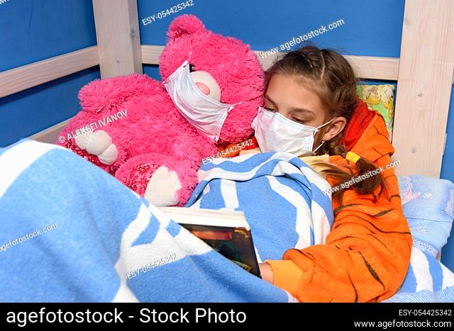 Girl and plush toy in medical masks in bed read a book