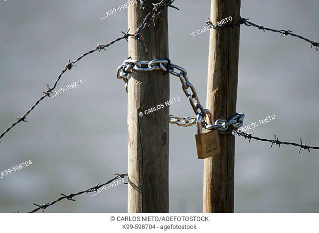 Wire fence with chain and padlock. Sanlucar de Barrameda. Càdiz. Andalucia. Spain