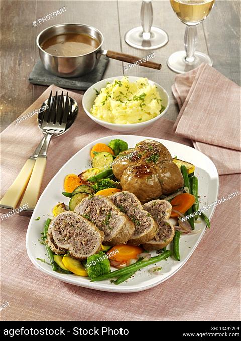 Veal roulades with minced meat stuffing on vegetables
