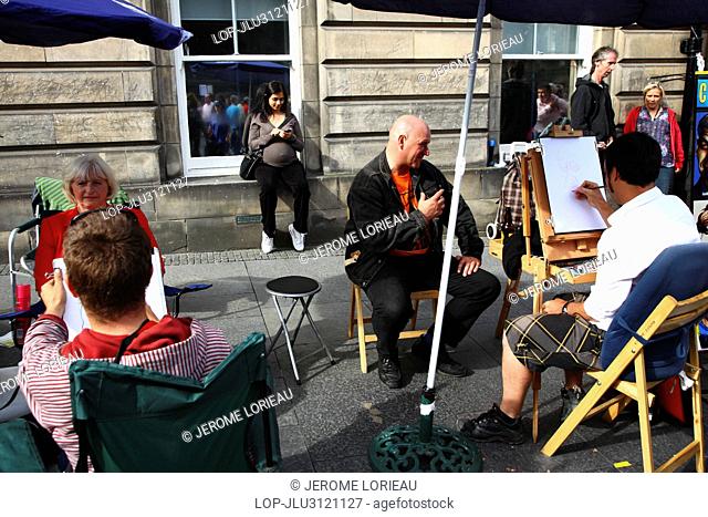 Scotland, City of Edinburgh, Edinburgh. Cartoonists sketching caricatures of people on the Royal Mile