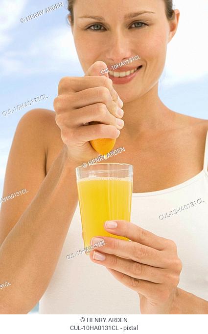 Hand squeezing orange juice
