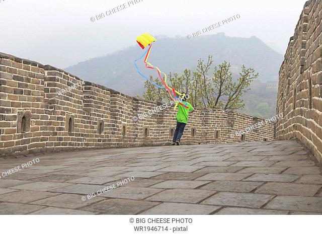 Boy running with a kite on the Great Wall of China, at Mutianyu, Huairou, China