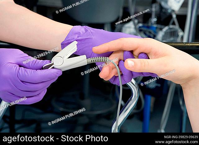 Surgeon putting finger clip on patient