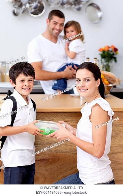 Radiant mother giving food to her son for lunch
