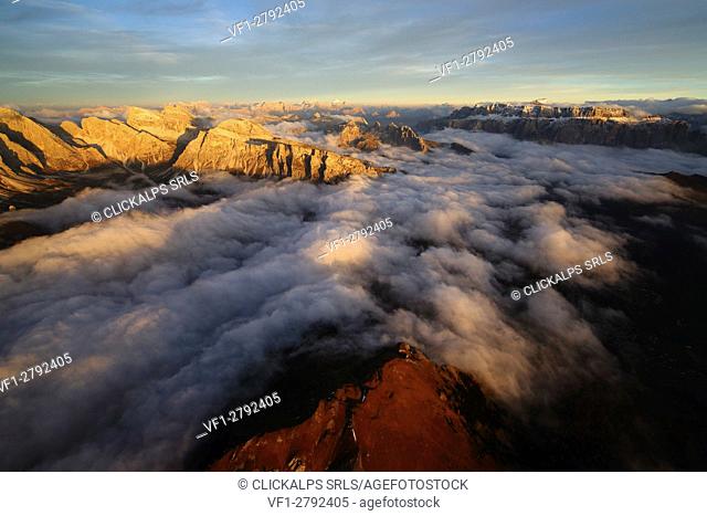 Aerial shot of Sella Group Alps surrounded by clouds at sunset. Dolomites Trentino Alto Adige. Italy Europe