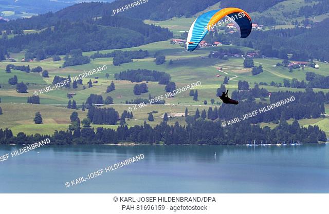 A paraglider hovering above Forggen lake near Buching, Germany, 1 July 2016. PHOTO: KARL-JOSEF ZHILDENBRAND/dpa | usage worldwide