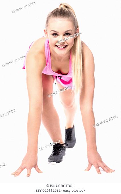 Young female athlete in about to run posture