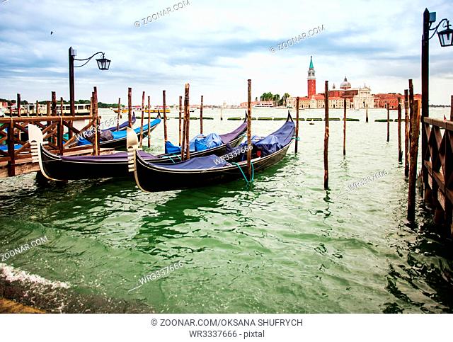 Traditional view from San Marco, Venice, Italy. Blue gondolas parked on Canal Grande, San Giorgio Maggiore church at the background