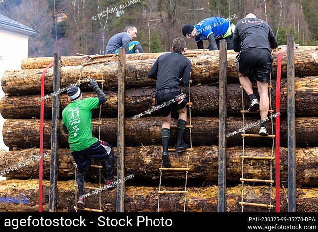 25 March 2023, Thuringia, Steinach: Participants of the obstacle race ""Braveheartbattle"" overcome a stack of wood. Over 20 or 10 kilometers