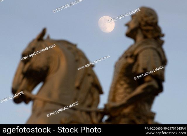 03 June 2020, Saxony, Dresden: The moon rises behind the equestrian statue of August the Strong, the so-called Golden Horseman