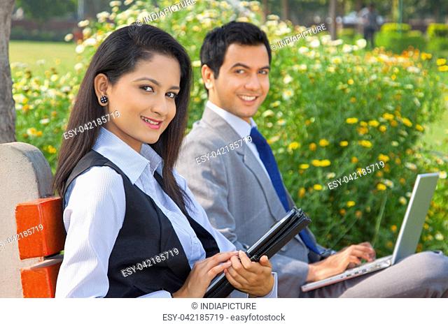 Businessman and businesswoman working in a park