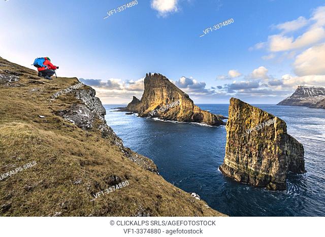 Photographer in front of the natural arch of Drangarnir and Tindholmur Islet (Vagar Island, Faroe Islands, Denmark) (MR)