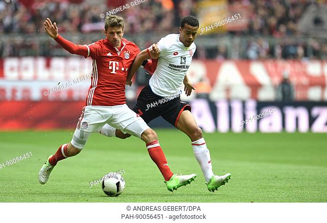 Munich's Thomas Mueller (L) and Mainz' Robin Quaison vie for the ball during the German Bundesliga soccer match between Bayern Munich and FSV Mainz 05 in the...