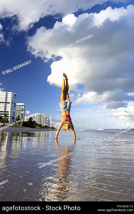 Woman doing yoga handstand on beach - Pompano Beach, Florida, USA
