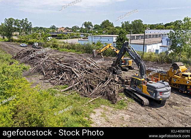Detroit, Michigan - Using heavy equipment, workers clear trees, shredding them into woodchips, from an abandoned railroad right of way