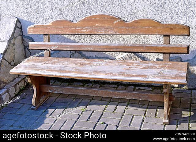 Elegant carved antique wooden empty bench standing on an open paved area