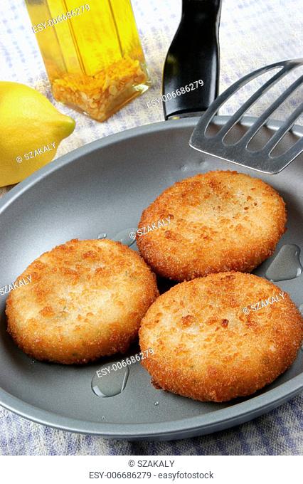 three freshly fried fish cakes in a pan