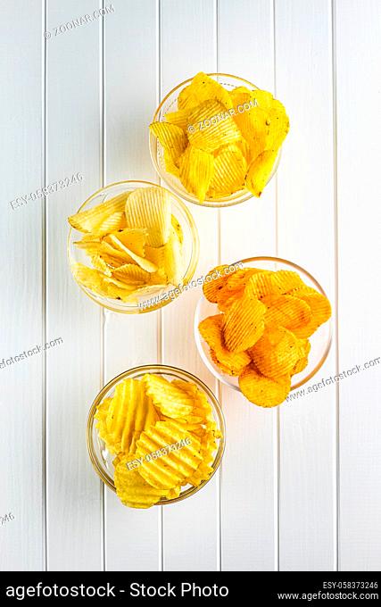 Crispy potato chips with various taste in bowl. Top view