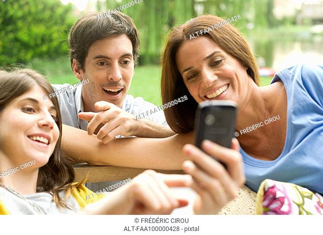 Young woman sharing photos on smartphone with friends