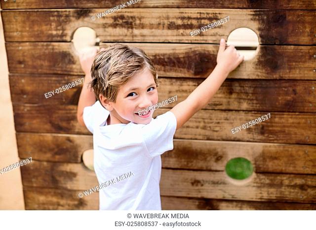 Boy climbing on a playground ride in park