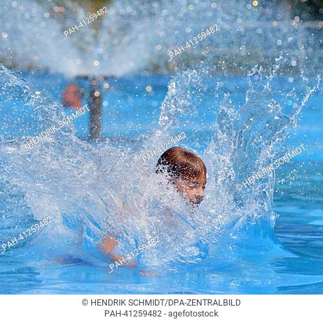 A boy jumps into the water in the bath of Rebesgruen, Germany, 24 July 2013. This weekend the 17th German water sliding championship will take place in the bath