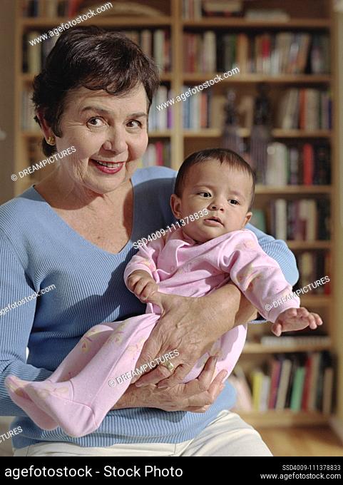 Middle-aged woman cradling her baby granddaughter