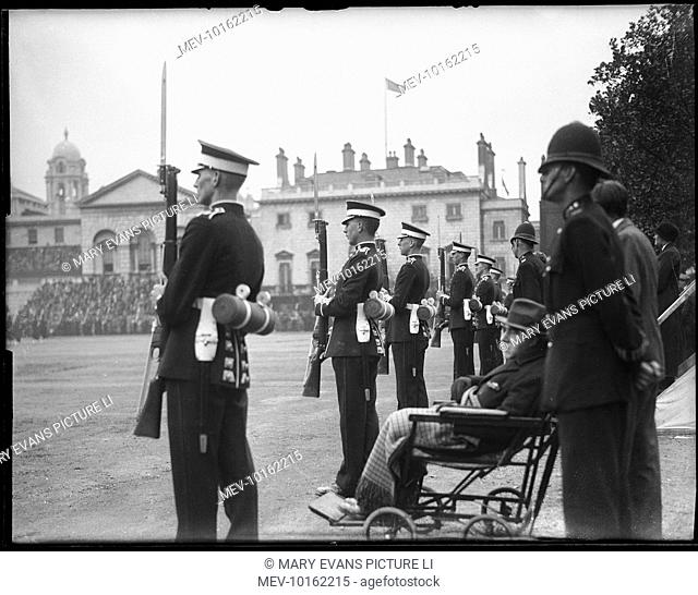 A policeman and a man in a wheelchair are among the spectators of the rehearsal for the Trooping of the Colour at Horseguards Parade, Whitehall, central London