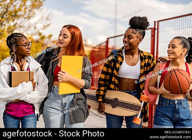 Young woman walking with friends on footpath