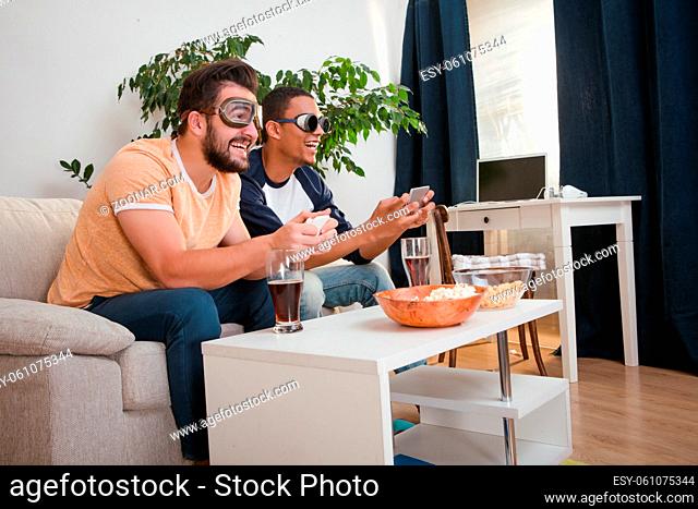 Image of happy friends playing computer games with help of their mobile or smart phones after ard working day or week at home
